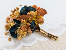 Boutonnière de marié artisanale en fleurs stabilisées oranges et bleues verts Nila par Flora Paris