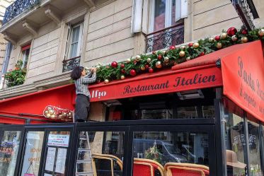 Pose d'une guirlande pour la décoration de noël du restaurant Alfio