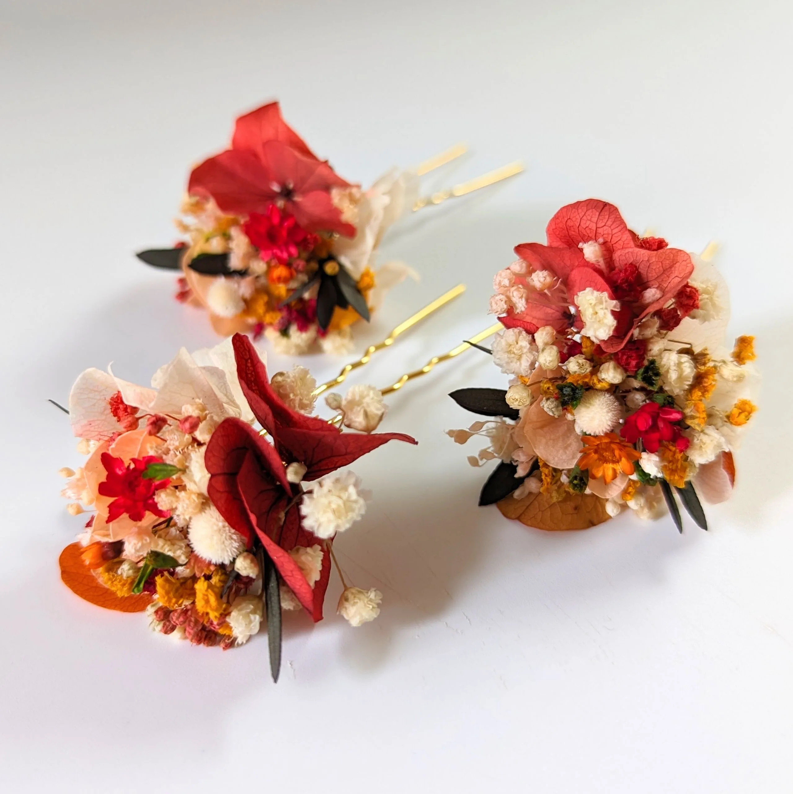 Épingle à cheveux ornée de fleurs stabilisées aux tonalités rouges, Coco Cinelle