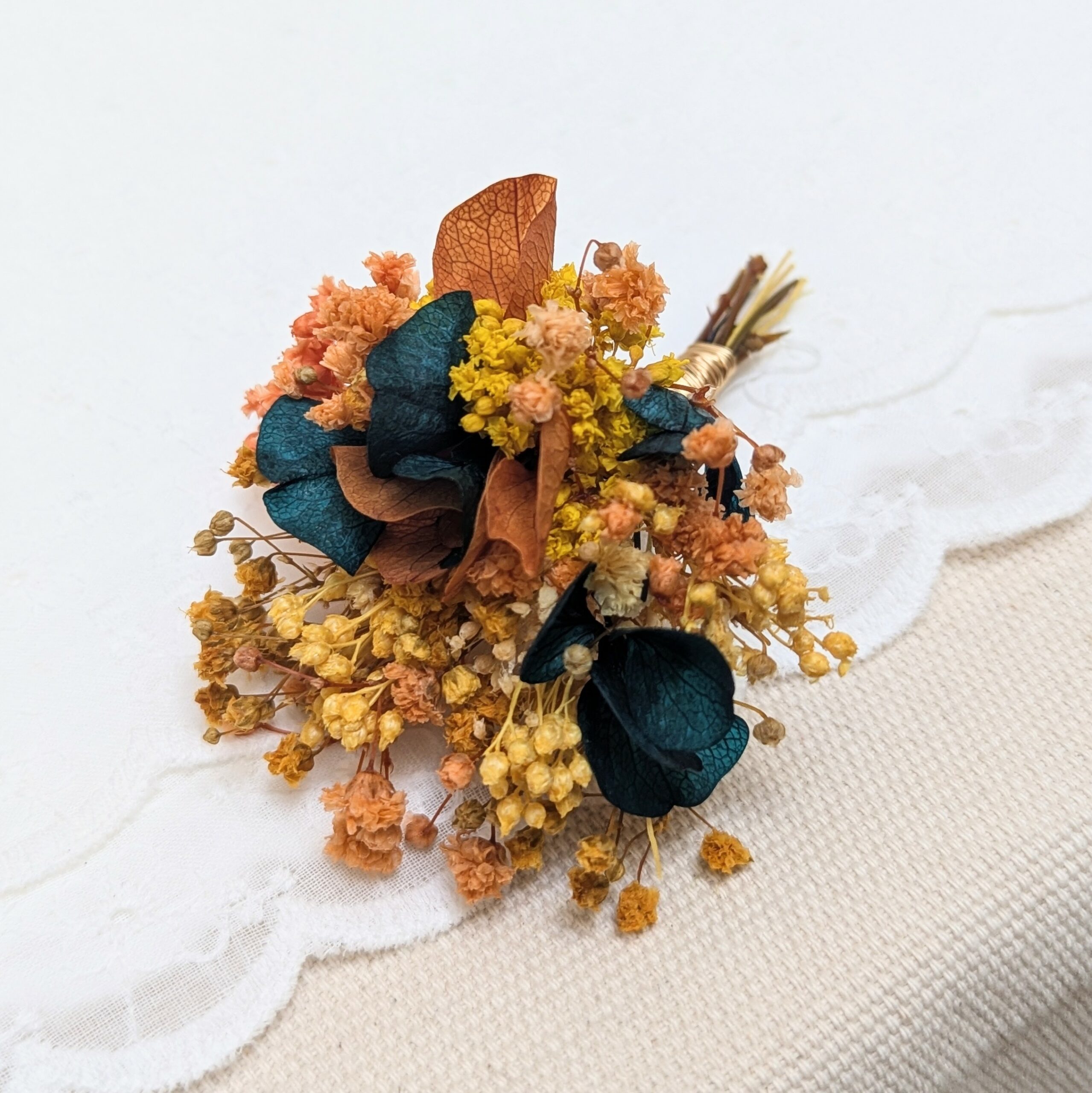 Boutonnière de marié artisanale en fleurs stabilisées oranges et bleues verts, Nila – Image 3