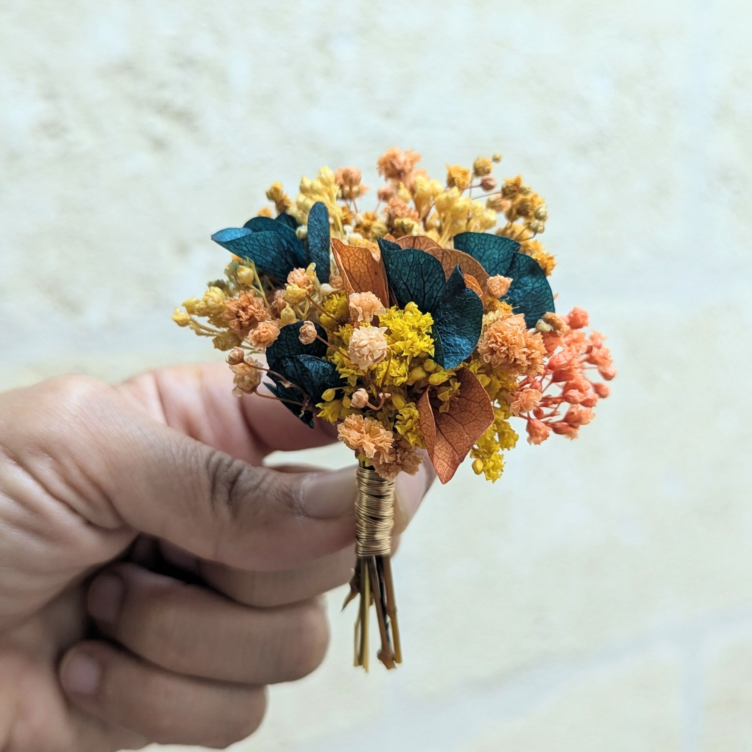 Boutonnière de marié artisanale en fleurs stabilisées oranges et bleues verts, Nila – Image 2