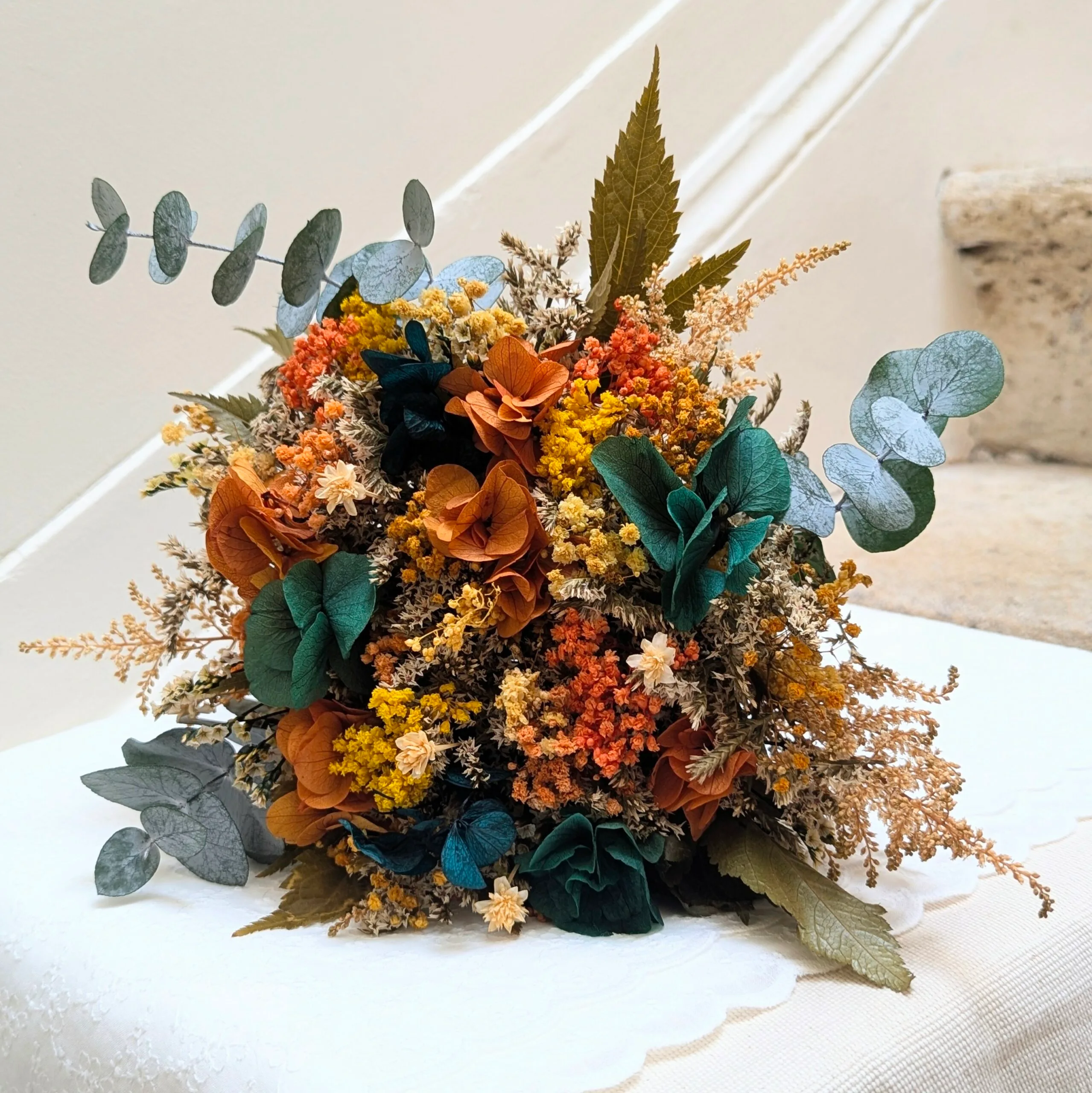 Bouquet de mariée en fleurs stabilisées oranges et bleu-vert, Nila
